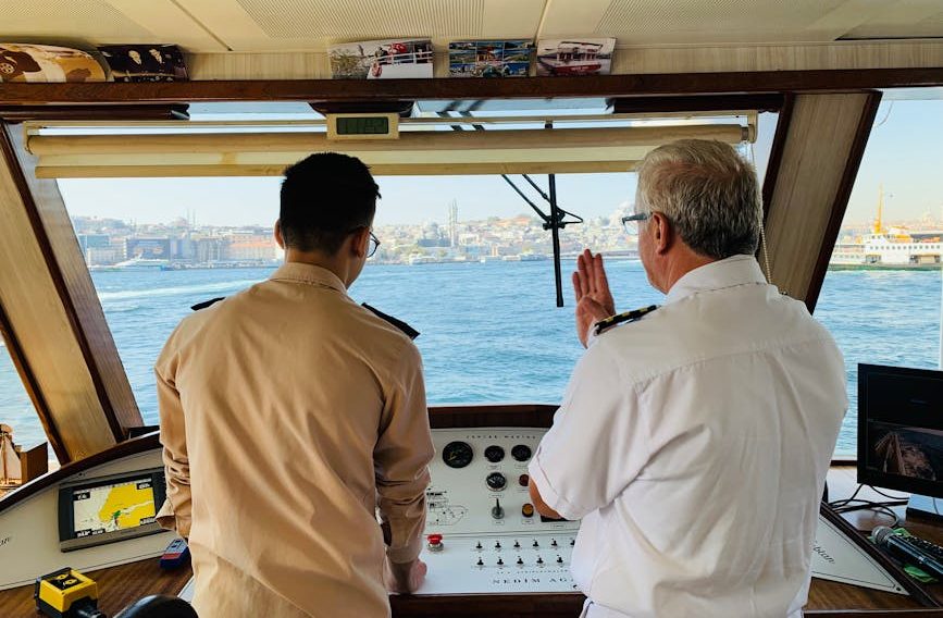 Ship captain and crew member discussing navigation on the Bosphorus in Istanbul.